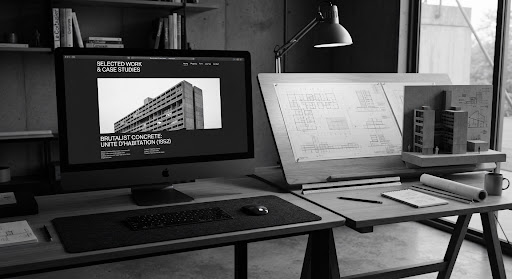Editorial desktop setup displaying brutalist concrete architecture on an Apple workstation